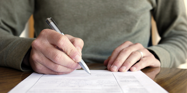 Man using pen to complete paper form